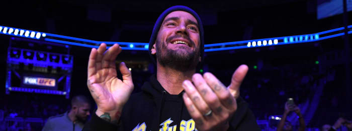 CM Punk claps at a UFC event